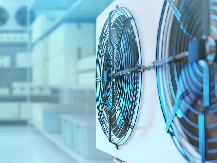 Großflächige Lüfter mit Schutzgittern in einer industriellen Kühllagerhalle.