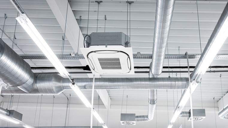 Deckenansicht mit runden Lüftungsrohren und einer Deckenklimaanlage.